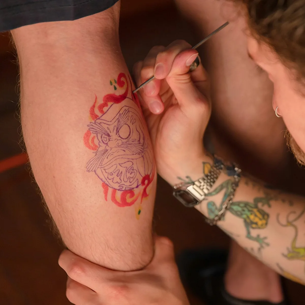 Tatoueur en train de tatouer un avant-bras